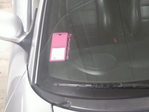 Pochette étui assurance voiture PORCHE rose poser sur auto de couleur gris un super rendu sur ce véhicule.
